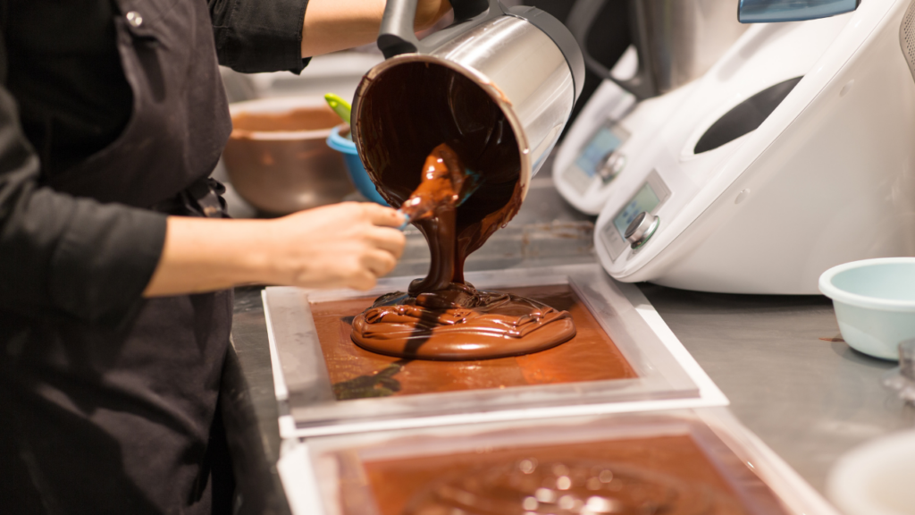 Chocolate confectioner pouring chocolate