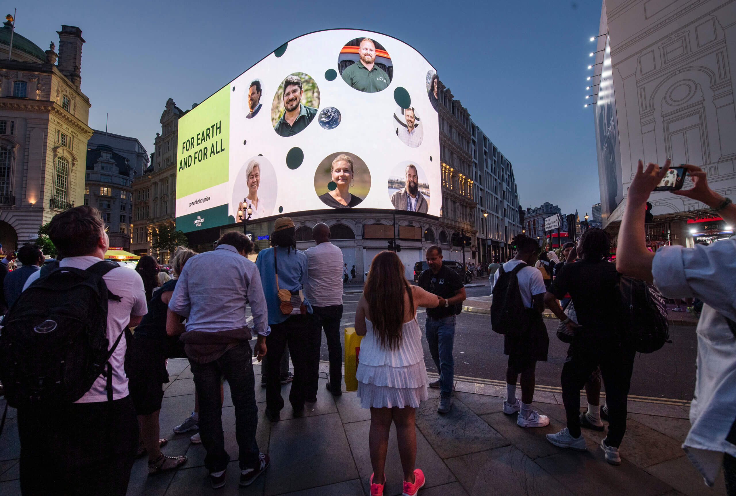 People standing in front of a screen showing the Earthshot finalists