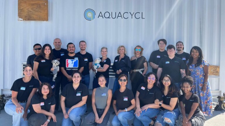 picture of Aquacycl employees in front of an Aquacycl wastewater treatment system